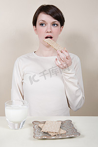 简单性摄影照片_吃着可口饼干的年轻女子