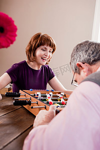 游戏玩法摄影照片_一对老夫妇在玩桌上足球游戏