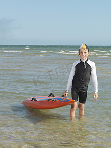 澳大利亚墨尔本阿尔托纳男孩尼珀儿童冲浪救生员举着冲浪板的肖像