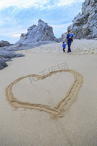 父子俩走在海滩上前景中的心形