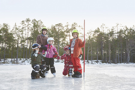 瑞典加夫勒冰湖上戴着滑雪头盔的女孩和男孩的肖像