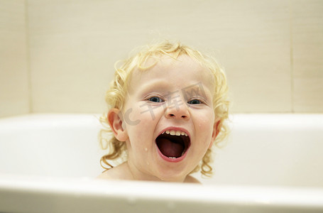 人洗澡摄影照片_男孩在浴缸里玩耍