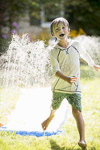 玩花园洒水器的男孩