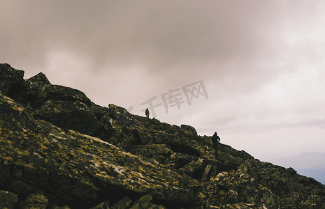 两名男子在崎岖的岩石上徒步旅行的剪影俄罗斯乌拉尔山脉