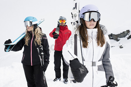 朋友们戴着头盔和滑雪护目镜手持滑雪板肖像