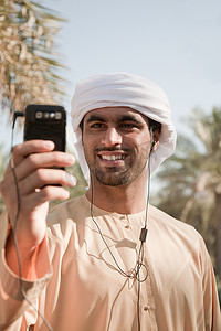 一名中东男子在手机上听音乐