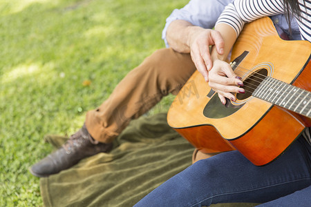 一对情侣坐在草地上弹着原声吉他的截图