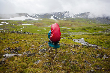 年轻男子在俄罗斯乌拉尔山脉山谷徒步旅行的背影