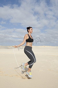 中年妇女在海滩上跳绳锻炼