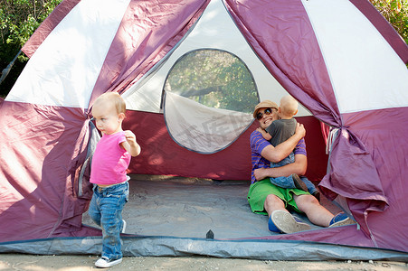 同心同向同心同行摄影照片_住在帐篷里的父亲和幼儿双胞胎