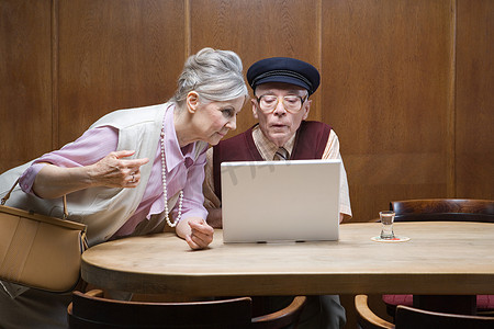 互联网科技感摄影照片_酒店里的一对老年夫妇带着笔记本电脑