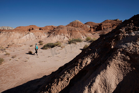 走在美国犹他州埃默里地精谷州立公园沙漠中的一名女子