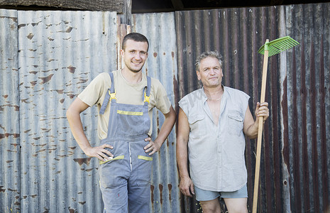 两位男性农场工人在农家庭院里的肖像
