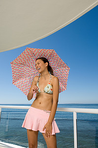 阳台上撑着伞的快乐女人
