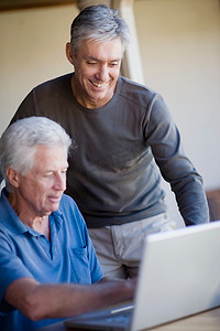 老年男性一起使用笔记本电脑