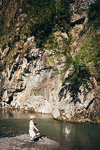 全身摄影照片_奥地利多恩伯恩男孩向水中扔石头的全身侧视