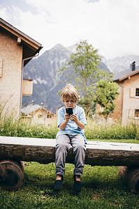男孩坐在木凳上使用数码相机布卢登兹奥地利沃拉尔贝格