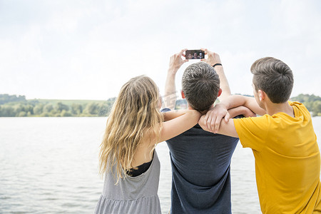 三个年轻人用智能手机自拍后视镜