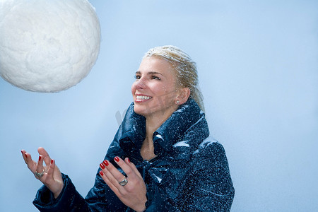 温度和人摄影照片_一名年轻女子扔出大雪球