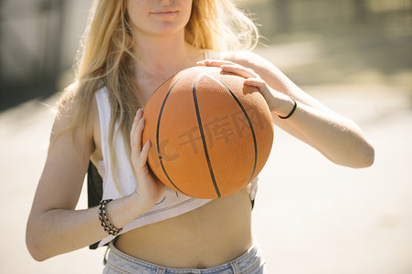 裁剪室摄影照片_在篮球场上练习的年轻女子的中段