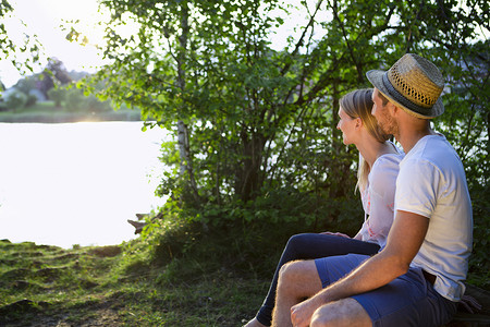 一对中年夫妇坐在湖边看日落