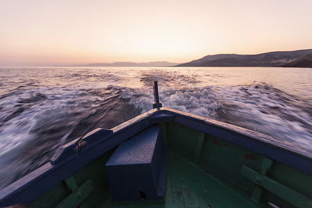 日落时船只在海浪中鞠躬意大利撒丁岛加卢拉的卡波特斯塔