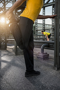 德国巴伐利亚州慕尼黑桥上伸展腿的男子