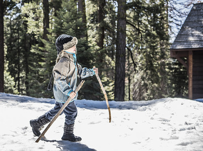 美国加利福尼亚州红杉国家公园小男孩用木棍在雪地里行走