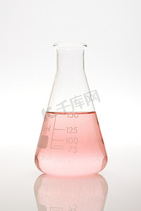 透明纯色摄影照片_容量瓶中的粉红色液体