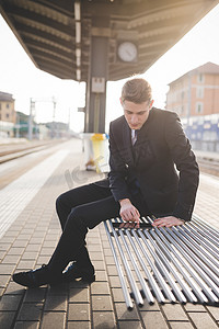 年轻商人通勤者在火车站使用数字平板电脑的肖像