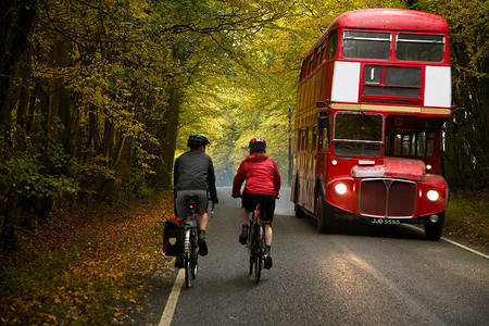 在乡村一对夫妇在公交车旁边骑自行车
