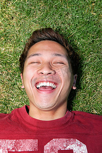 一个男人躺在草地上笑着