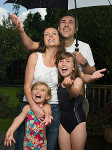 雨中撑伞摄影照片_雨中撑伞的一家人