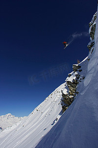 微妙摄影照片_滑雪者从悬崖上跳下