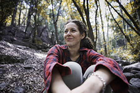 森林中的桥摄影照片_坐在森林里的年轻女性徒步旅行者阿卡迪亚美国