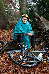 一位年轻人骑着自行车坐在森林里