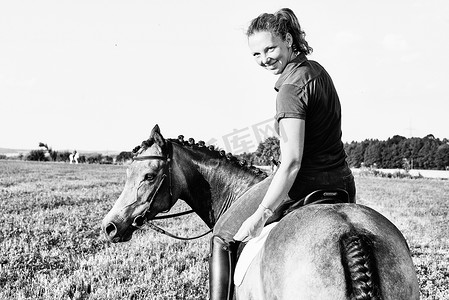 黑白画像女人在田野里骑马回头看
