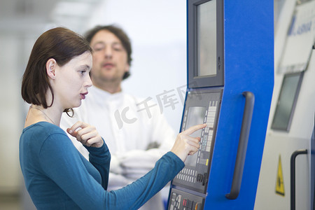 年轻女子在科学设备上按下键盘的侧视