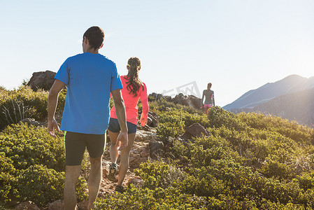 美国加利福尼亚州松树谷太平洋山顶小径土路上的三个成人小径跑步朋友的背影
