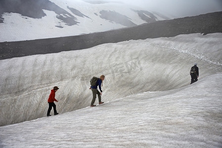 家人在积雪的山坡上徒步旅行