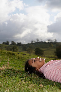 躺在草地上望着天空的女孩