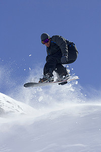 至低摄影照片_滑雪板运动员在斜坡上玩技巧