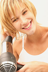 擦鼻涕摄影照片_微笑的年轻女子在擦头发