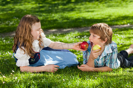 女孩用苹果喂男孩