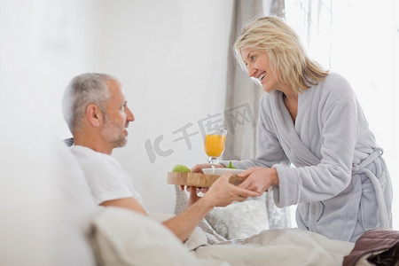 女人在床上给丈夫送早餐