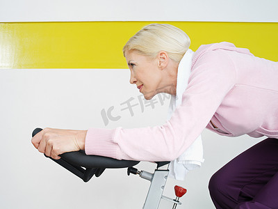 在健身俱乐部骑健身自行车的女人