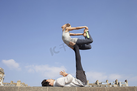 男人和女人在墙上练习杂技瑜伽平衡
