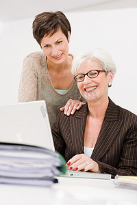 两个女人在一台电脑前一起工作