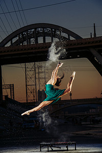 头爆炸摄影照片_美国洛杉矶日落时分女舞者一边跳跃一边释放火药爆炸