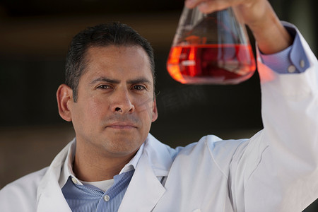 成熟的科学家在容量瓶中观察液体